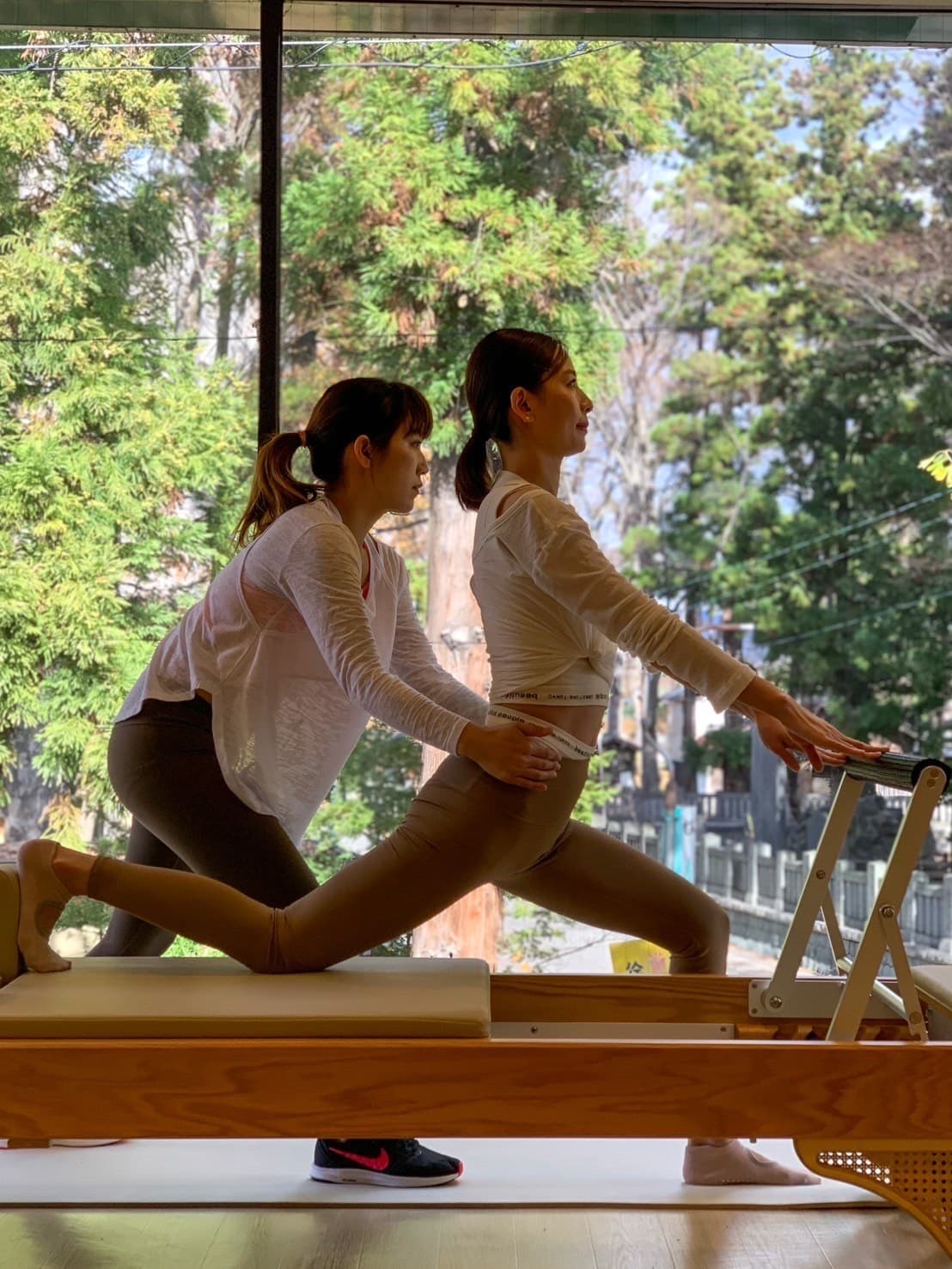 Studio L home image, a teacher adjusting student's posture